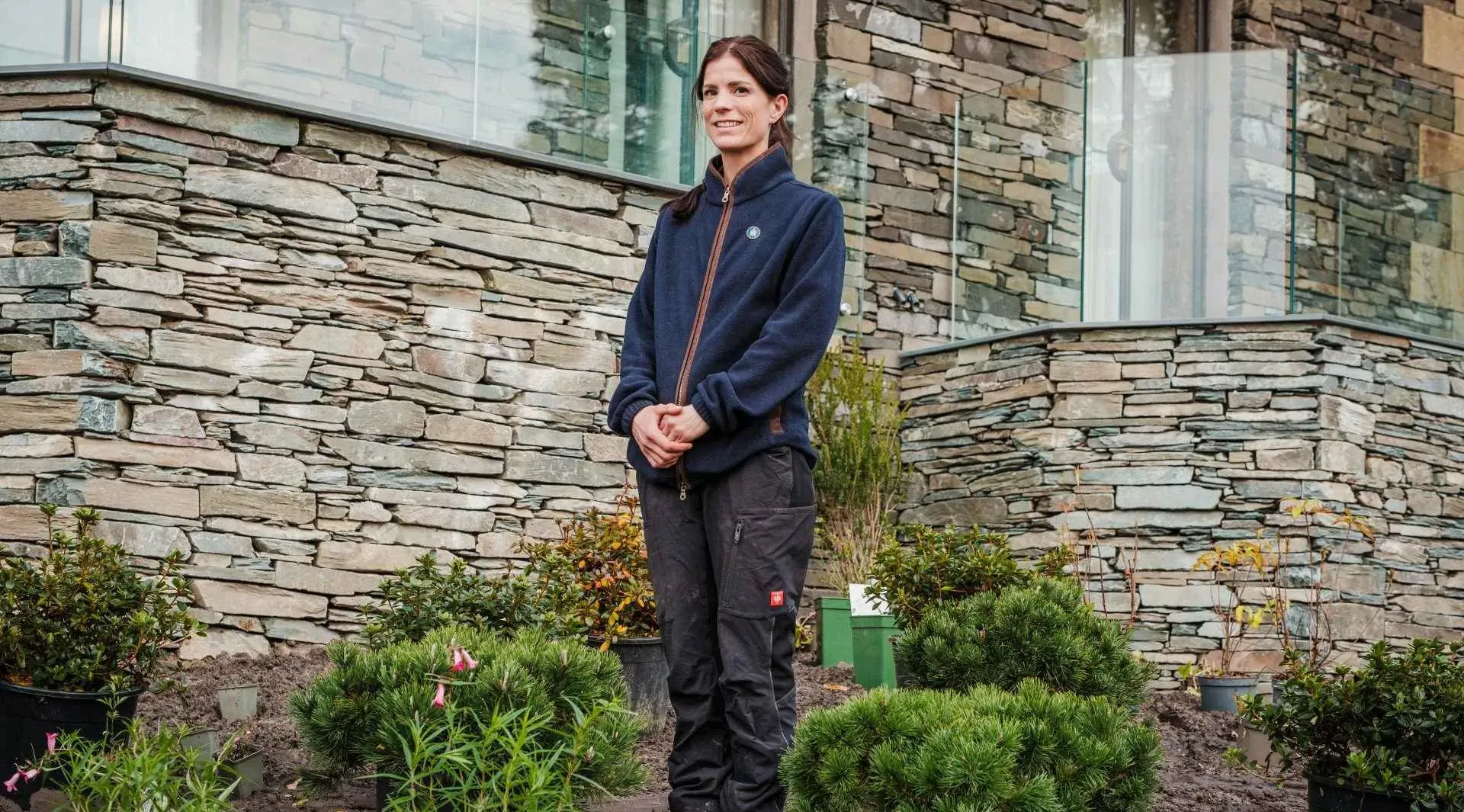 Claire Farrington, Langdale Chase's Head Gardener standing in front of a building