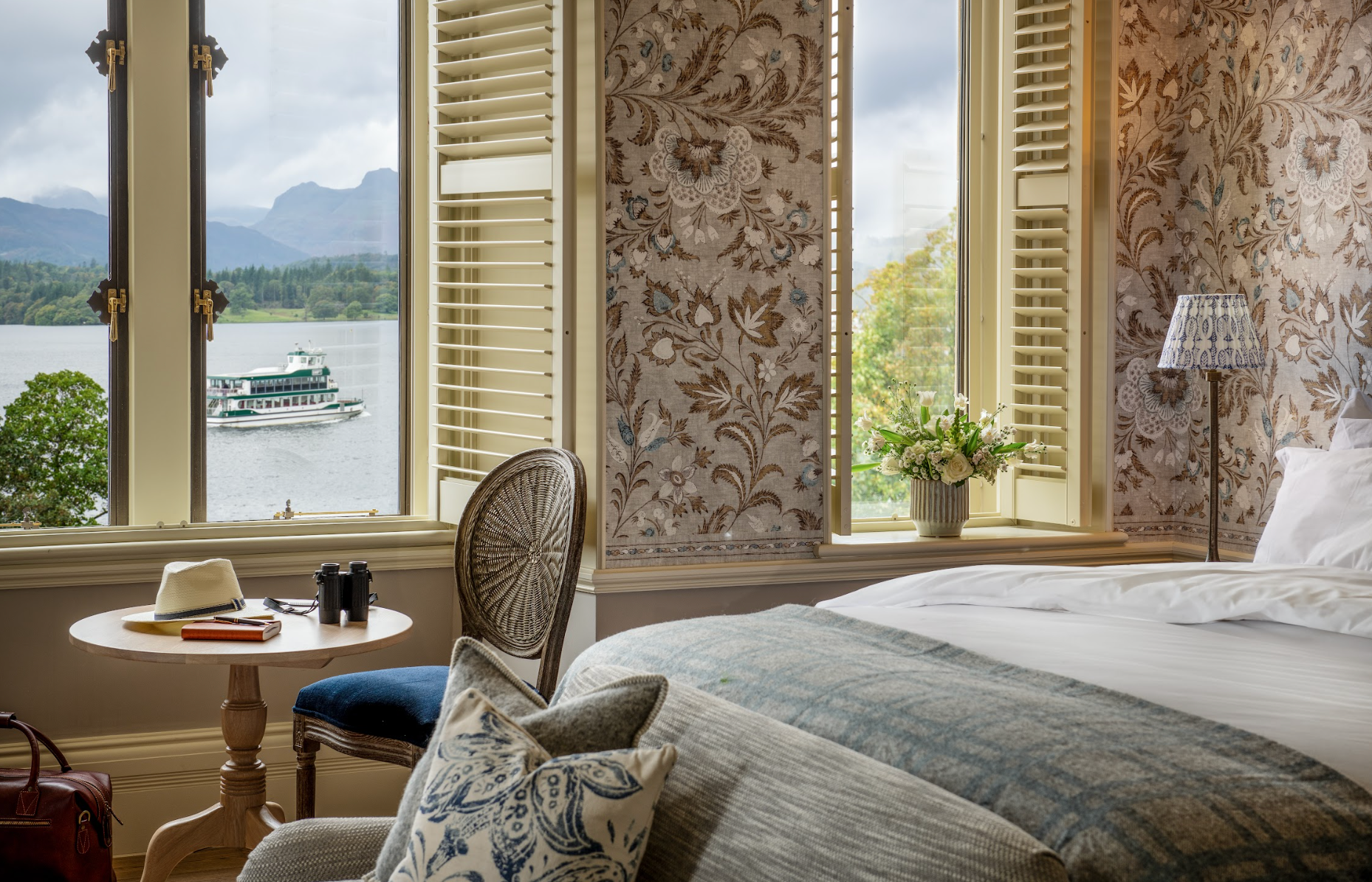 A spacious bedroom with a sofa and a lake view