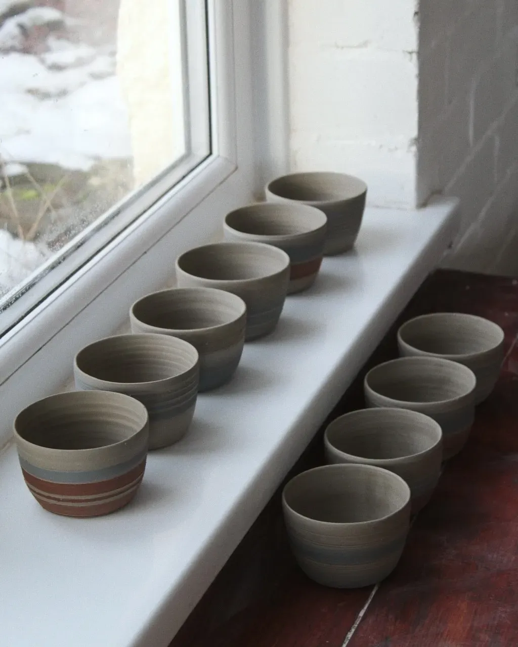 ceramic bowls lined up on a window ledge