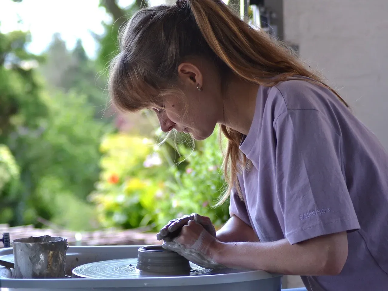 Lauren Frost handcrafting ceramics in front of a window