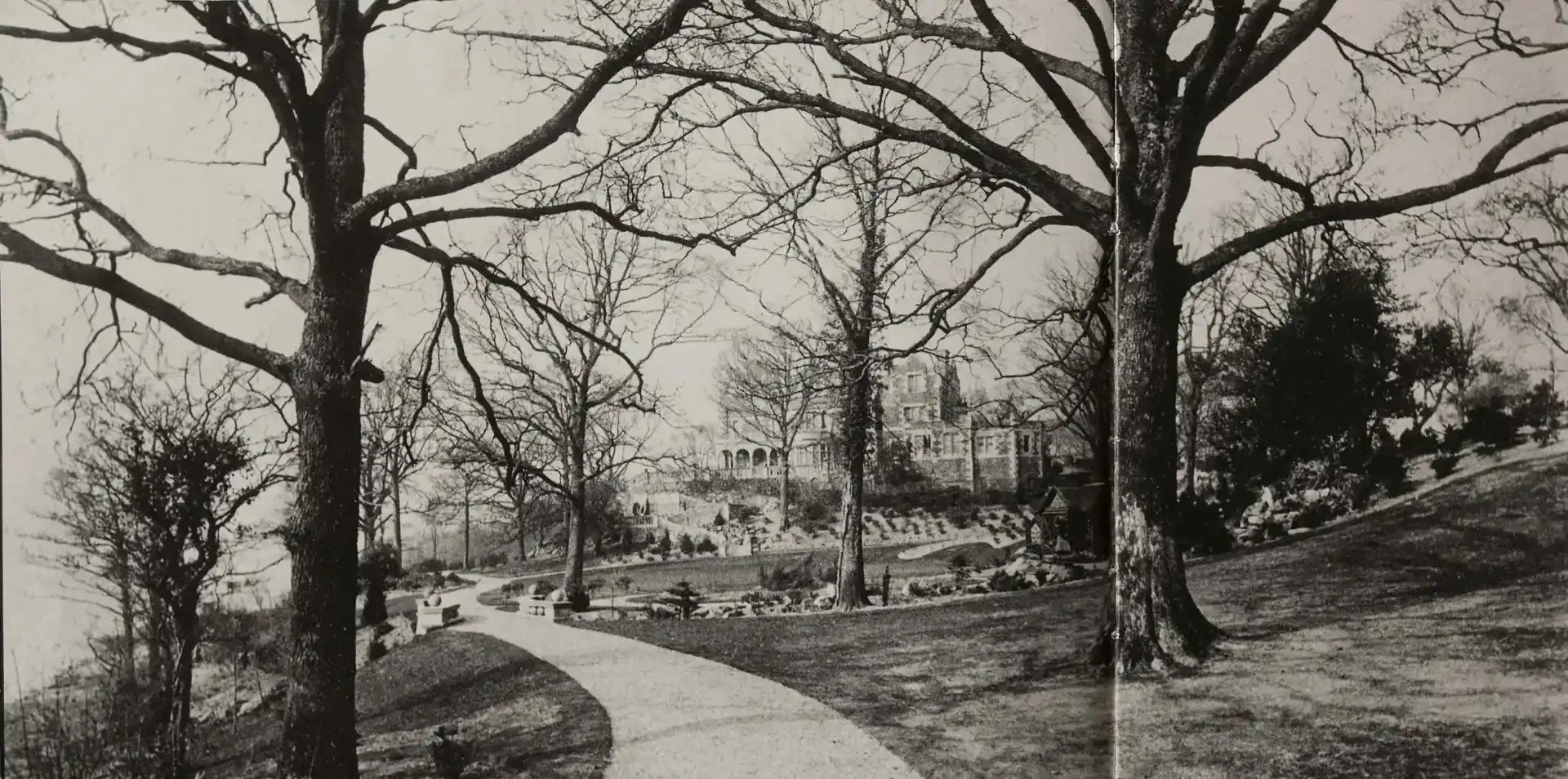 black and white photo of a Victorian-era mansion with a path leading to it