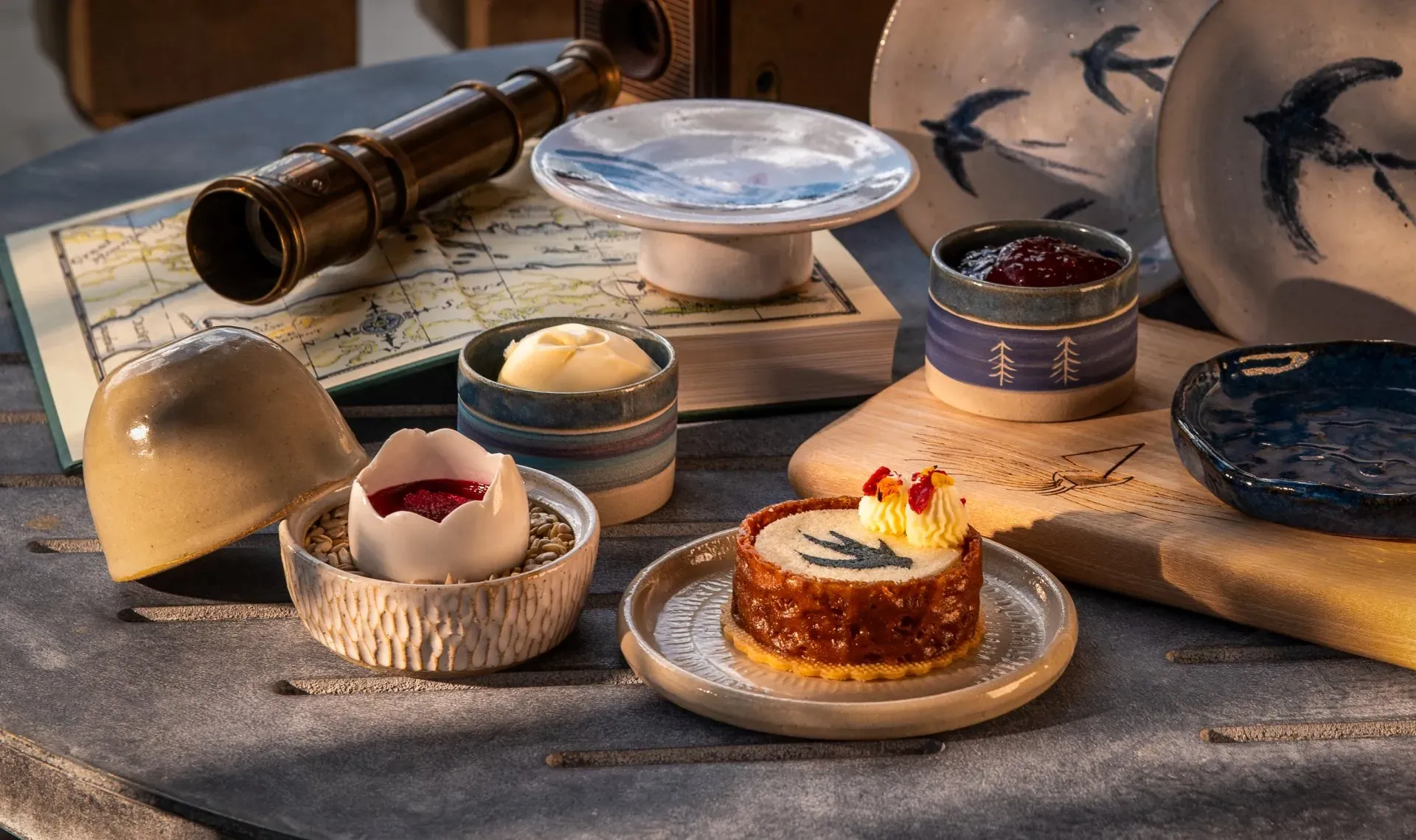 afternoon tea with bird-themed pastries and ceramic dishes